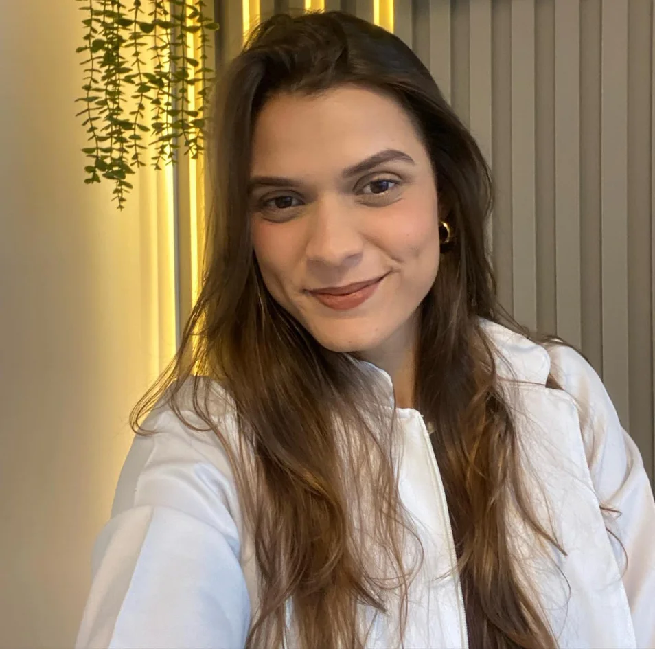 Vitória Avoni, nutricionista, sorrindo em seu consultório